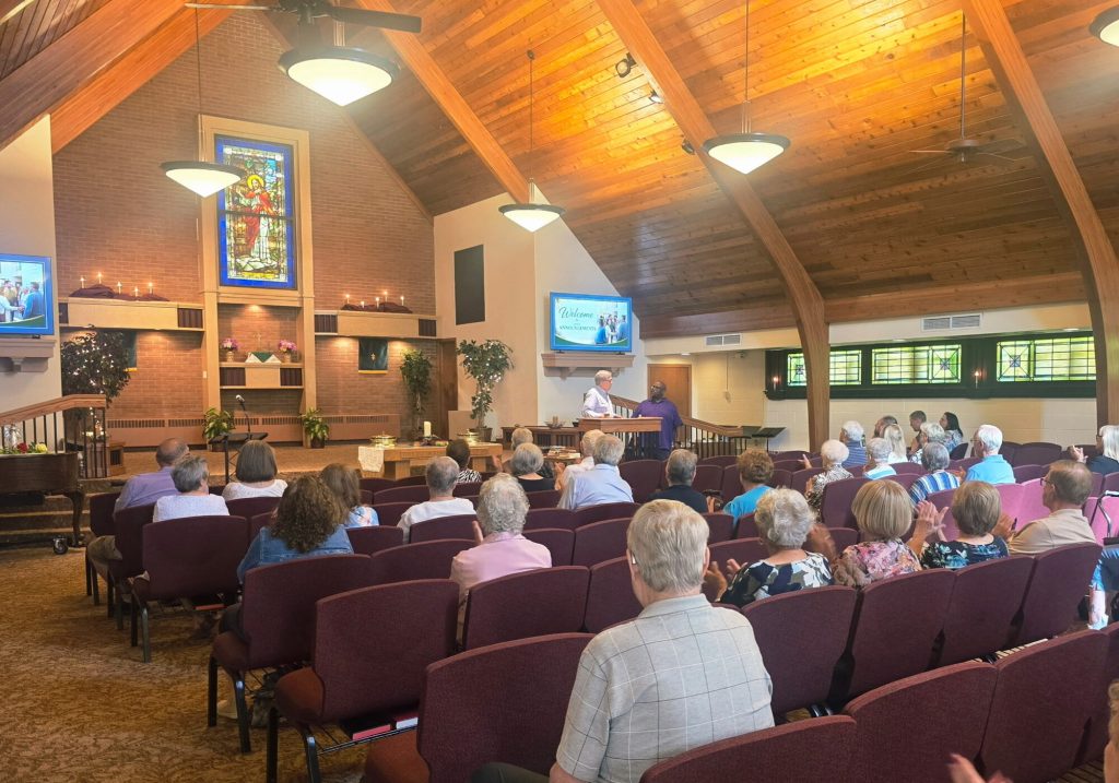 The congregation seated in the sanctuary, facing the front of the church